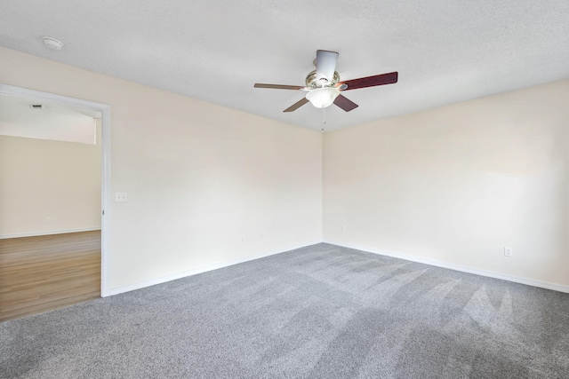 unfurnished room featuring carpet floors, a textured ceiling, baseboards, and a ceiling fan