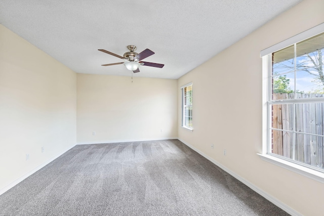 carpeted spare room featuring ceiling fan, a textured ceiling, and baseboards