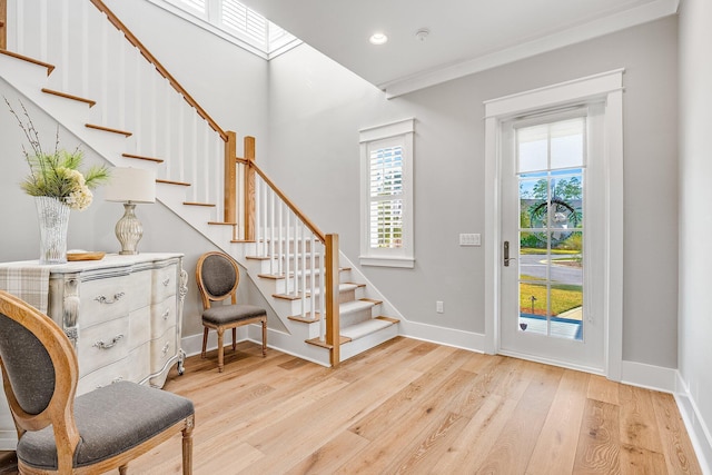 entrance foyer with recessed lighting, wood finished floors, baseboards, stairs, and ornamental molding