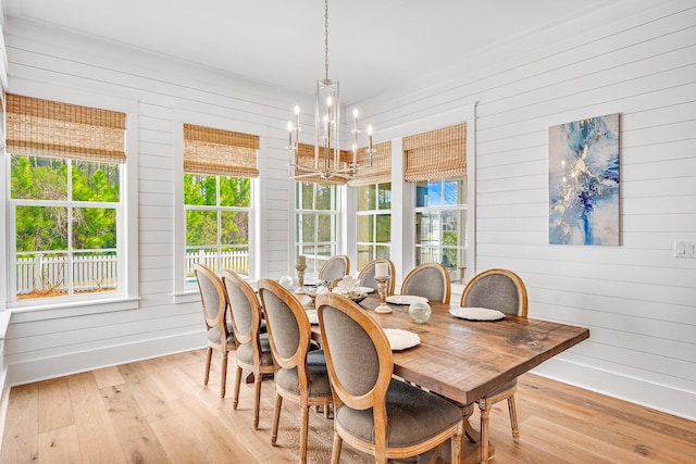 dining room with a chandelier, light wood-type flooring, and baseboards