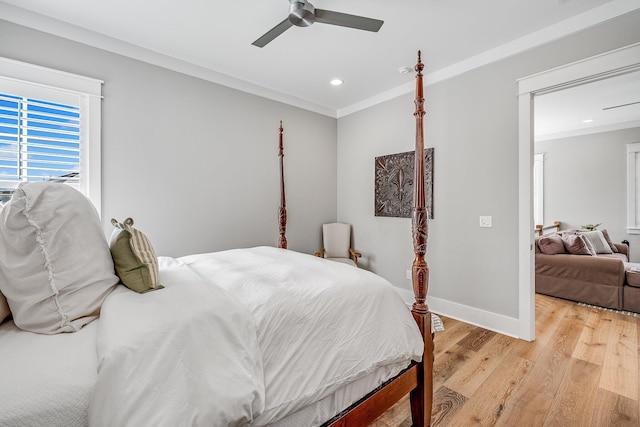 bedroom featuring ornamental molding, light wood-type flooring, ceiling fan, and baseboards