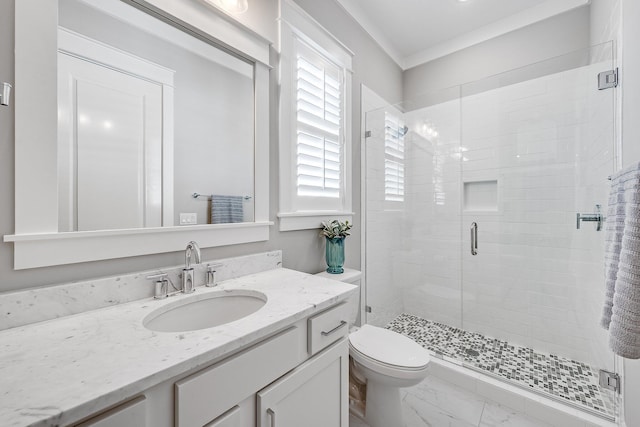 bathroom featuring toilet, vanity, marble finish floor, a stall shower, and crown molding