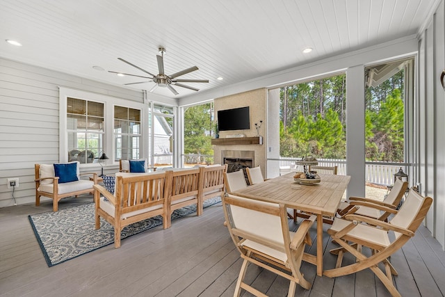 sunroom / solarium featuring wooden ceiling, a large fireplace, and plenty of natural light