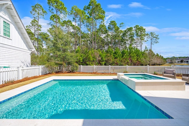 view of swimming pool featuring a fenced backyard, a pool with connected hot tub, and a patio