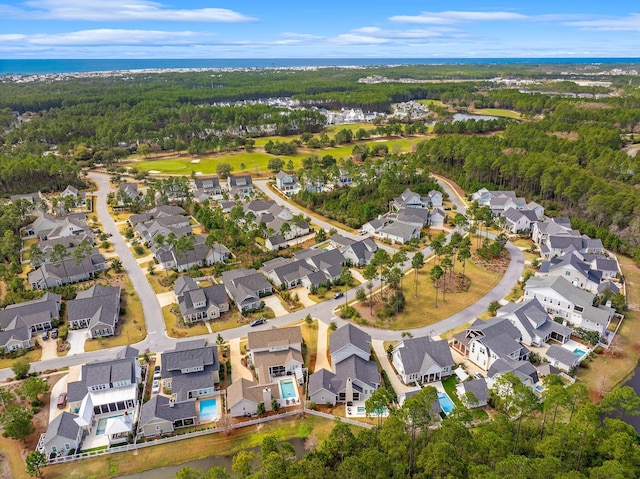 birds eye view of property featuring a forest view, a water view, and a residential view