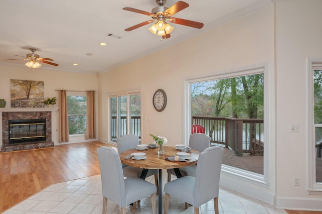 dining room with a high end fireplace, visible vents, ornamental molding, and light tile patterned flooring