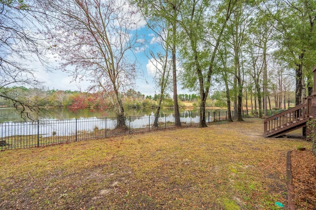 view of yard with a water view and a fenced backyard