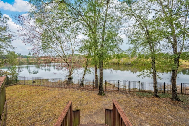 view of yard featuring a water view and fence