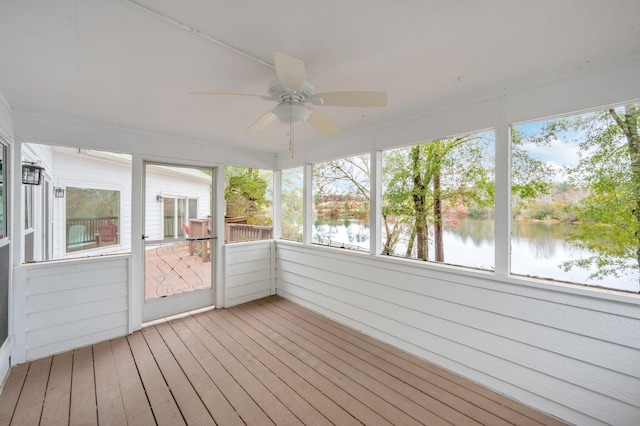 unfurnished sunroom featuring a water view and ceiling fan