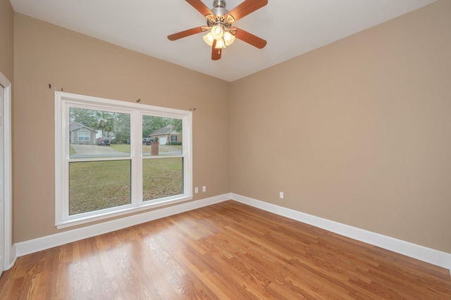 empty room featuring ceiling fan, light wood-type flooring, and baseboards