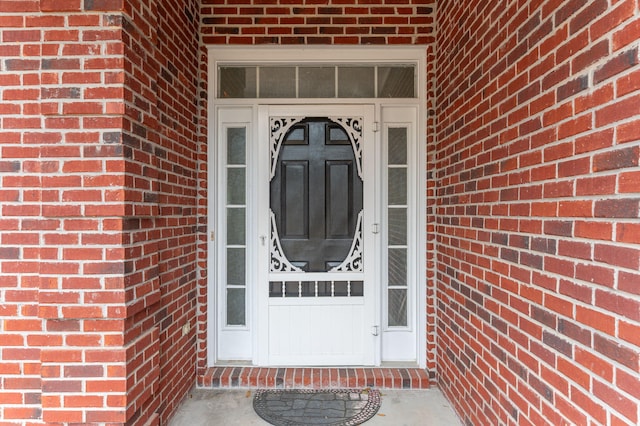 entrance to property featuring brick siding