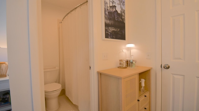 bathroom with a shower with shower curtain and toilet