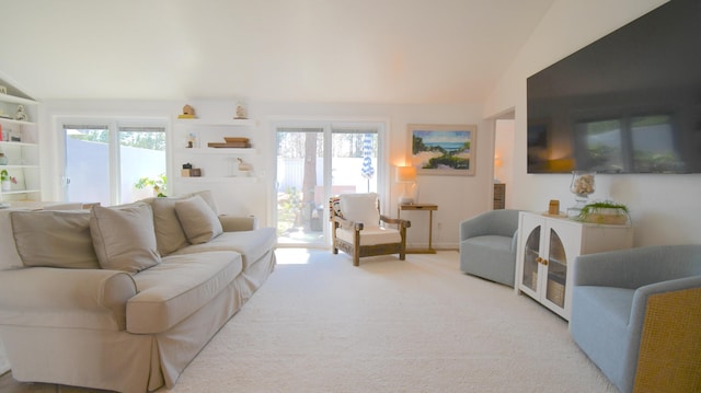 living room featuring lofted ceiling, plenty of natural light, and carpet flooring