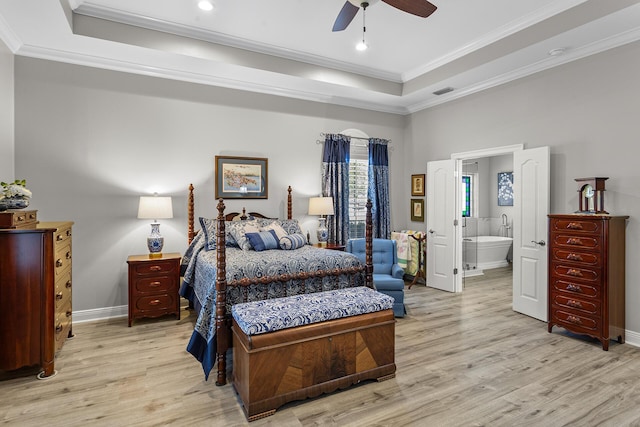 bedroom featuring light wood-type flooring, a tray ceiling, baseboards, and crown molding