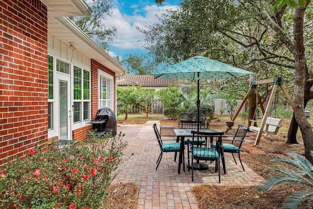 view of patio featuring outdoor dining space, fence, and grilling area