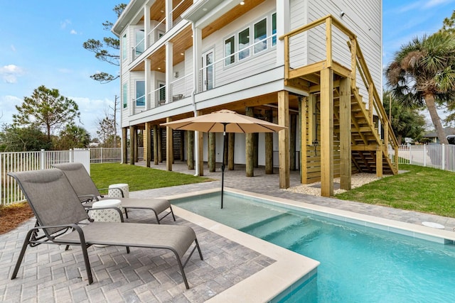 rear view of house with a fenced in pool, stairway, fence, a yard, and a patio area