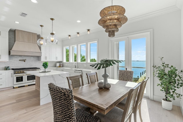 dining area featuring ornamental molding, visible vents, and a notable chandelier