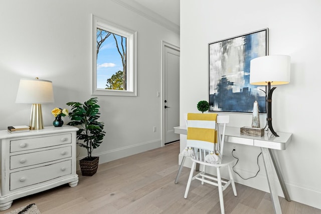 office area featuring crown molding, light wood finished floors, and baseboards