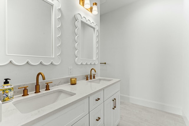 full bathroom with double vanity, a sink, and baseboards