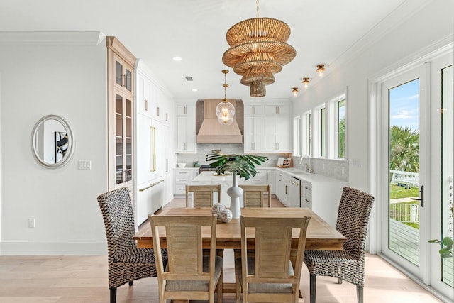 dining area featuring visible vents, baseboards, ornamental molding, light wood-type flooring, and an inviting chandelier