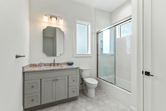 bathroom featuring bath / shower combo with glass door, vanity, toilet, and tile patterned floors