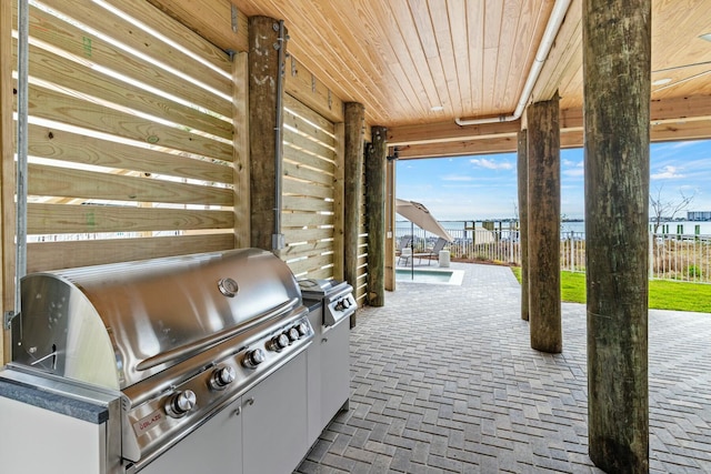 view of patio with exterior kitchen, fence, and grilling area