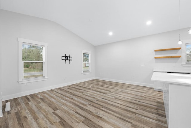 unfurnished room with lofted ceiling, baseboards, light wood finished floors, and recessed lighting