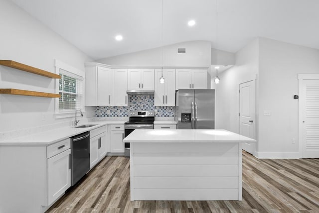 kitchen with white cabinets, stainless steel appliances, light countertops, and hanging light fixtures