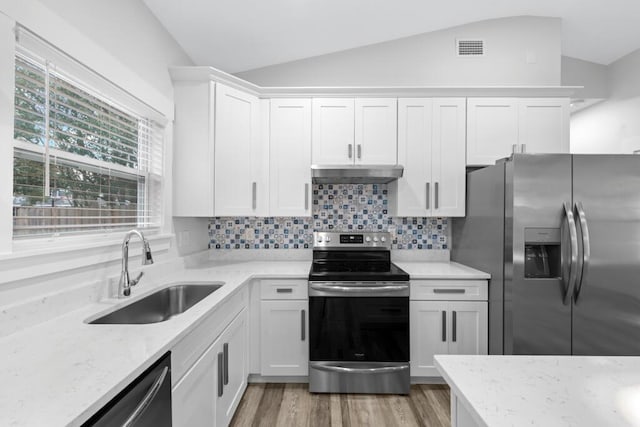 kitchen with stainless steel appliances, white cabinets, a sink, and under cabinet range hood