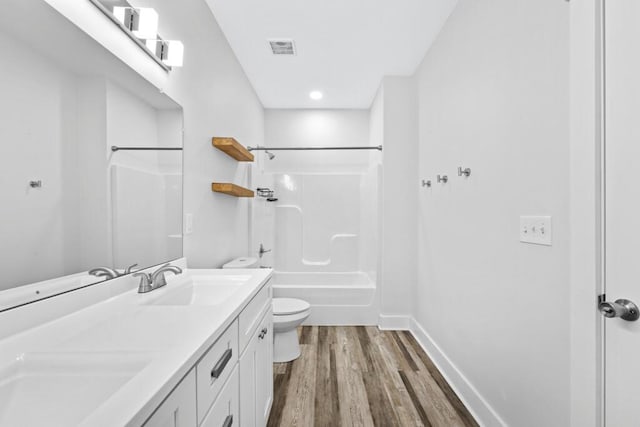 full bath with baseboards, visible vents, toilet, wood finished floors, and vanity