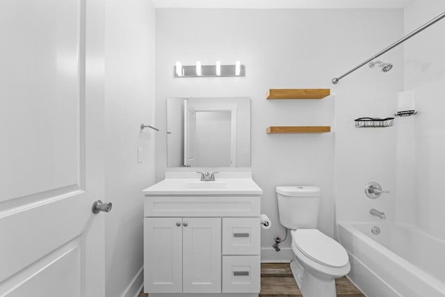 bathroom featuring bathtub / shower combination, toilet, vanity, wood finished floors, and baseboards