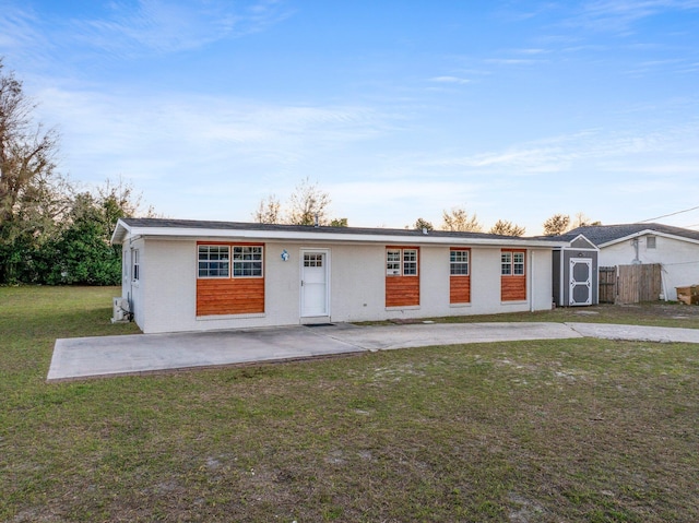 ranch-style home with a patio, a front lawn, and fence