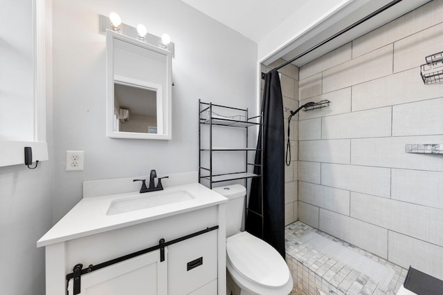 full bathroom with toilet, a tile shower, and vanity