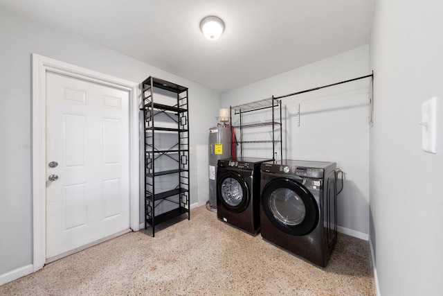 laundry room with water heater, laundry area, washer and clothes dryer, and baseboards