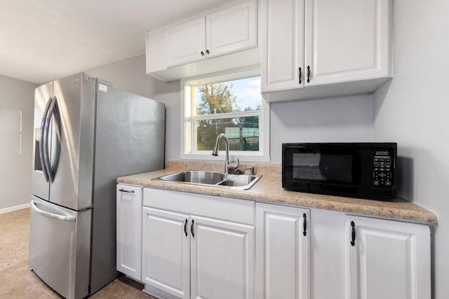 kitchen with black microwave, a sink, white cabinets, light countertops, and stainless steel refrigerator with ice dispenser