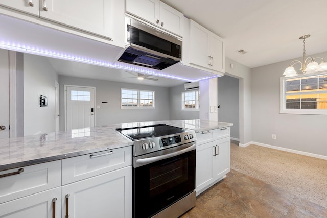 kitchen featuring appliances with stainless steel finishes, light stone countertops, white cabinetry, and baseboards