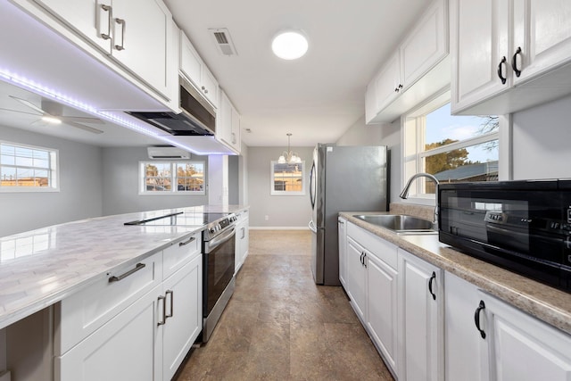 kitchen featuring white cabinets, a ceiling fan, appliances with stainless steel finishes, decorative light fixtures, and a sink