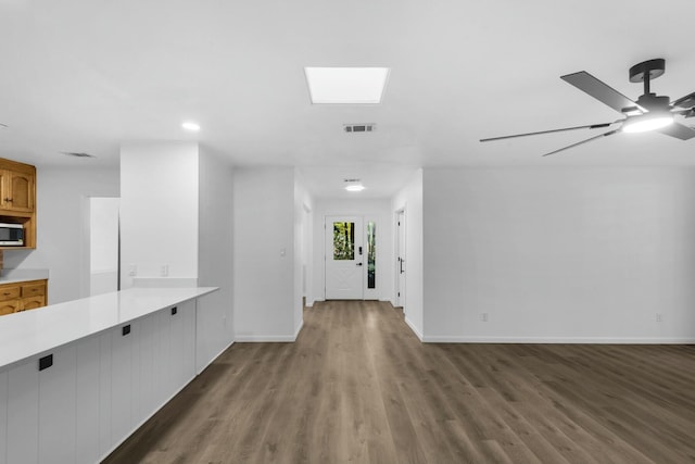 hallway featuring dark wood-style floors, visible vents, and baseboards