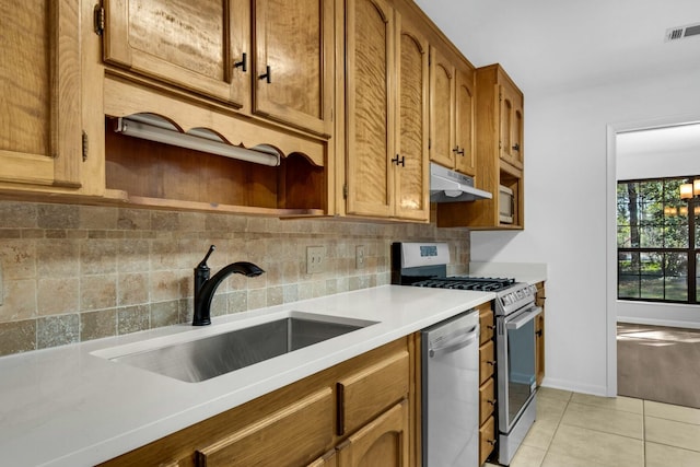 kitchen featuring stainless steel appliances, visible vents, decorative backsplash, a sink, and under cabinet range hood