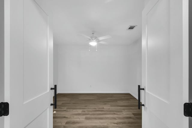 spare room with a ceiling fan, baseboards, visible vents, and wood finished floors