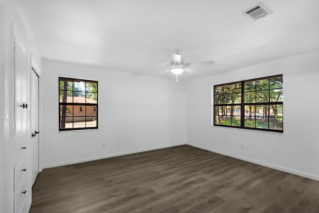 unfurnished bedroom featuring dark wood-type flooring, a closet, visible vents, and baseboards