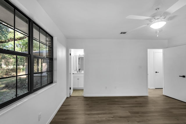 empty room with visible vents, baseboards, ceiling fan, and wood finished floors