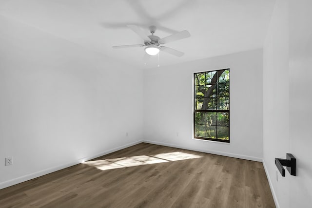 empty room with ceiling fan, baseboards, and wood finished floors