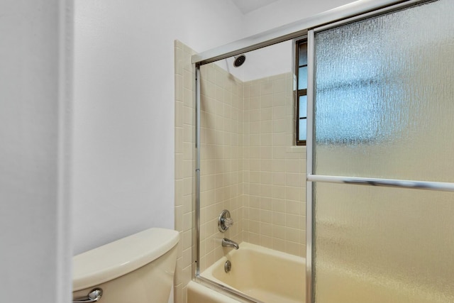 bathroom featuring shower / bath combination with glass door and toilet