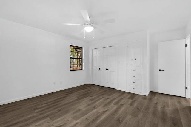 unfurnished bedroom with dark wood-style floors, baseboards, and a ceiling fan