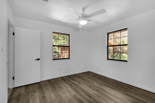 empty room with a ceiling fan, baseboards, and wood finished floors