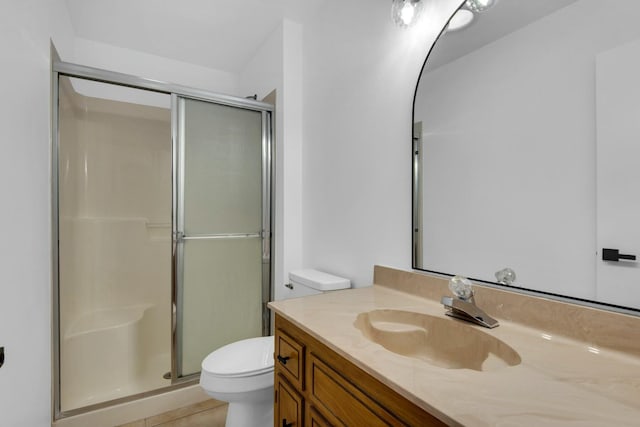 bathroom featuring a shower stall, toilet, and vanity