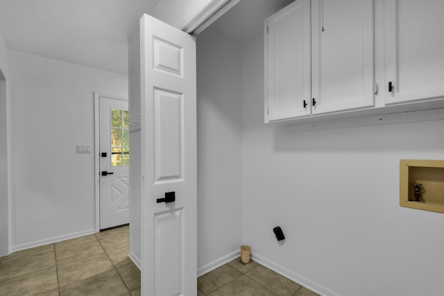 washroom featuring light tile patterned floors, washer hookup, cabinet space, and baseboards