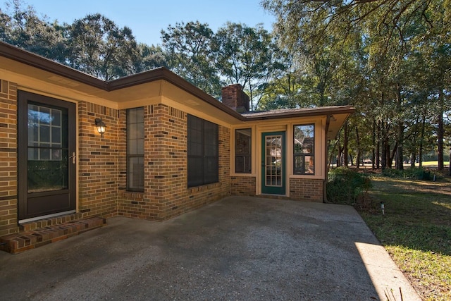 entrance to property featuring brick siding and a chimney