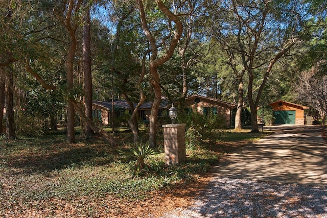 view of front of house featuring driveway, a garage, and an outdoor structure